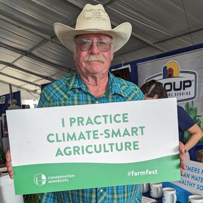 Farmfest farmer with selfie sign: climate smart ag