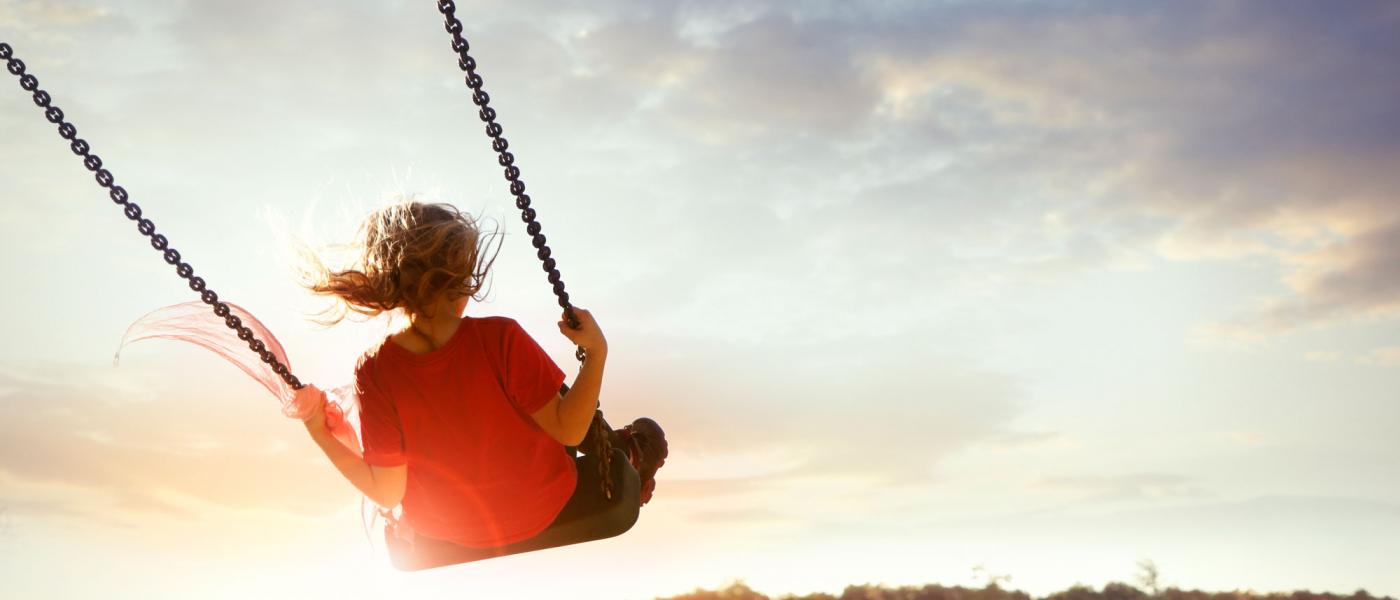 Girl on a swing at sunset
