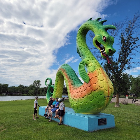 Mountain bikers enjoying the sea serpent sculpture donated by the Crosby Chamber of Commerce