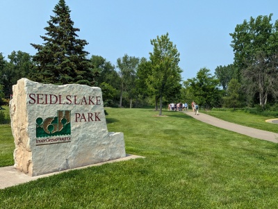 Seidels Lake Park sign and people walking into the park