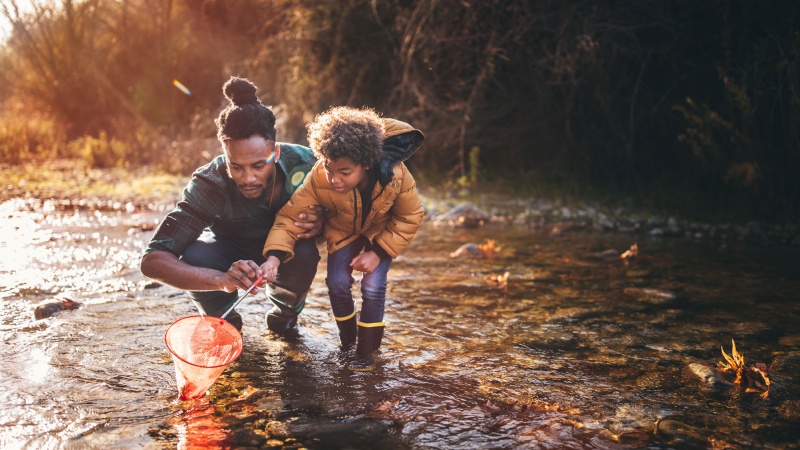 Dad and son fishing in stream