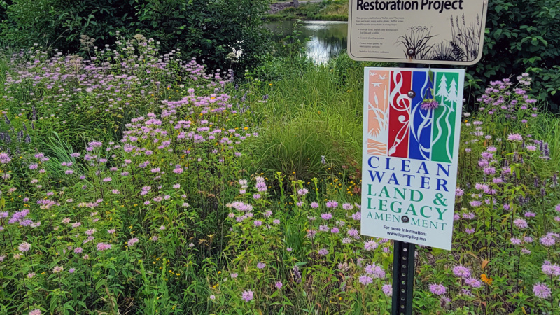 Clean Water Land and Legacy sign by prairie and pond