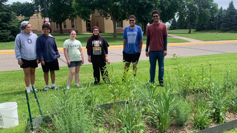 Students stand proudly by their garden