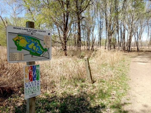 Clean Water, Land and Legacy sign by path in wooded park