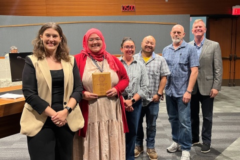 Group poses with award