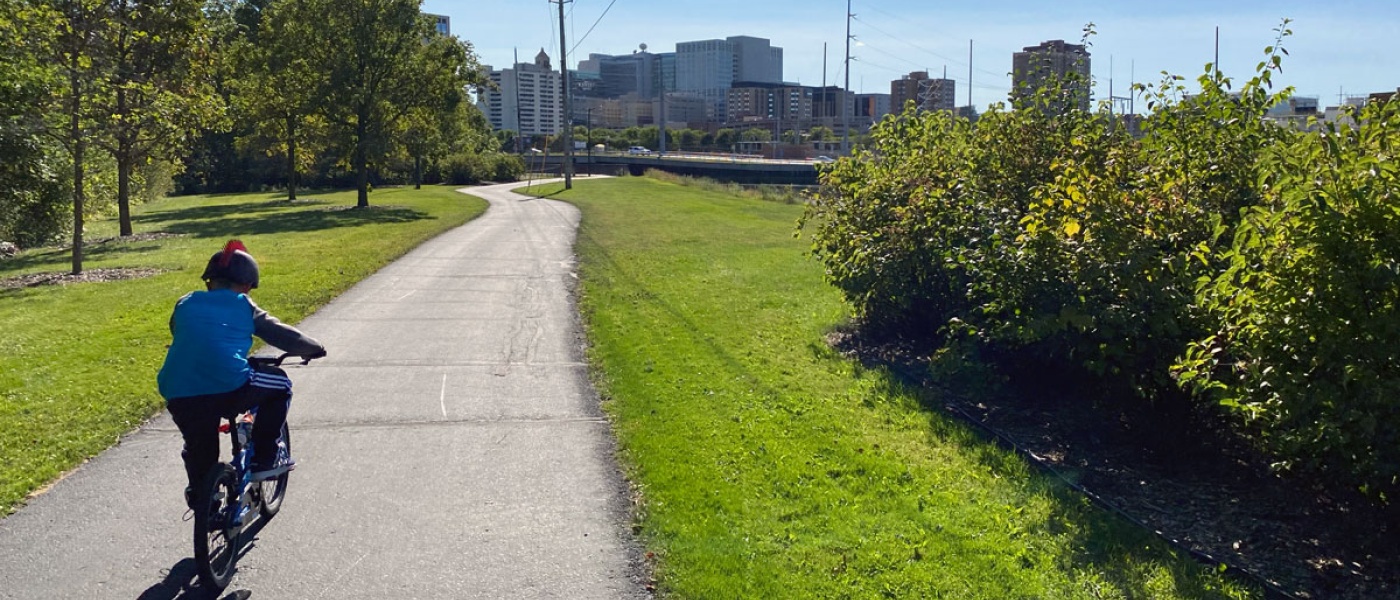 Child bikes on a path near city