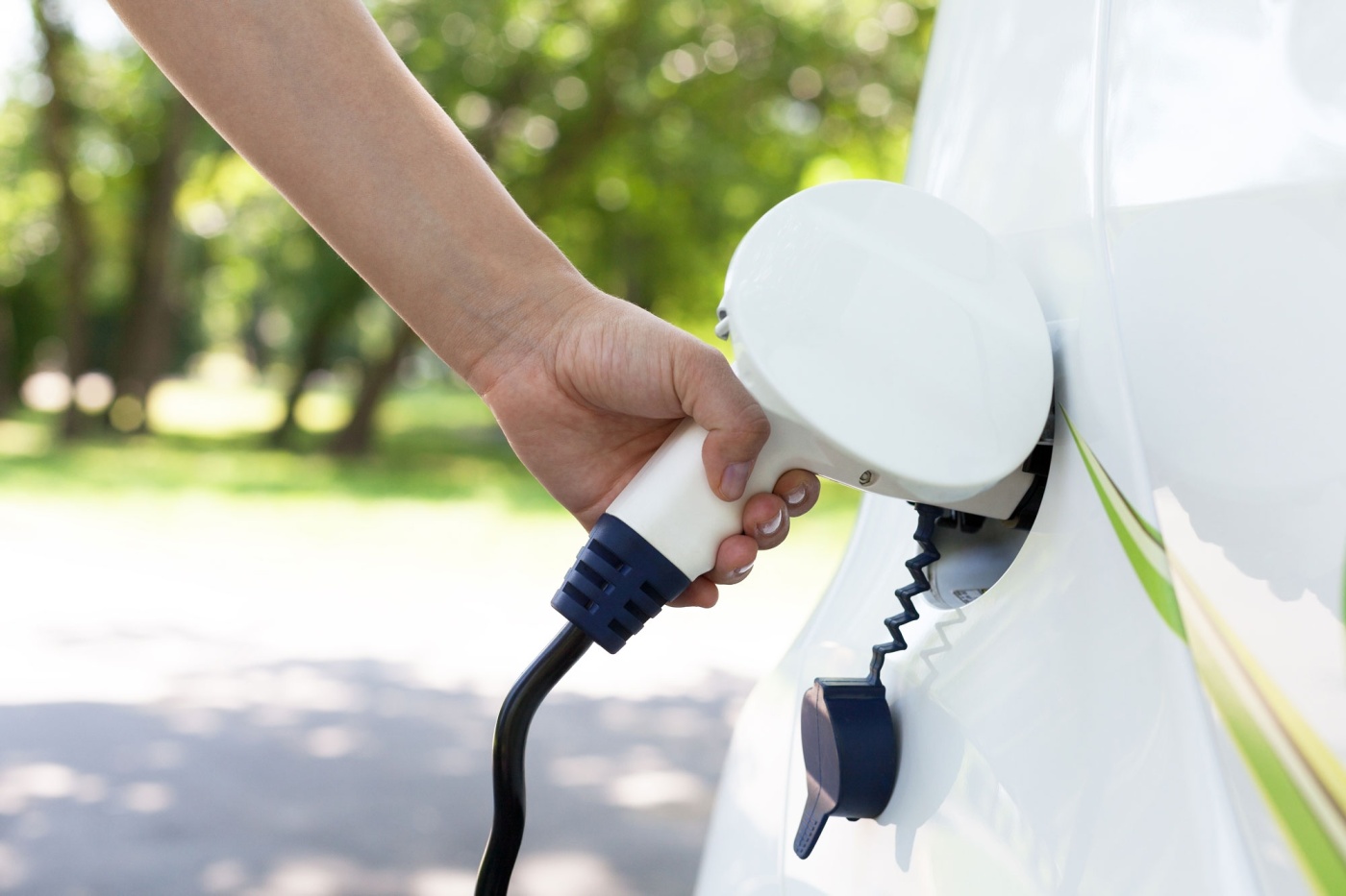 Close up of hand charging electric vehicle