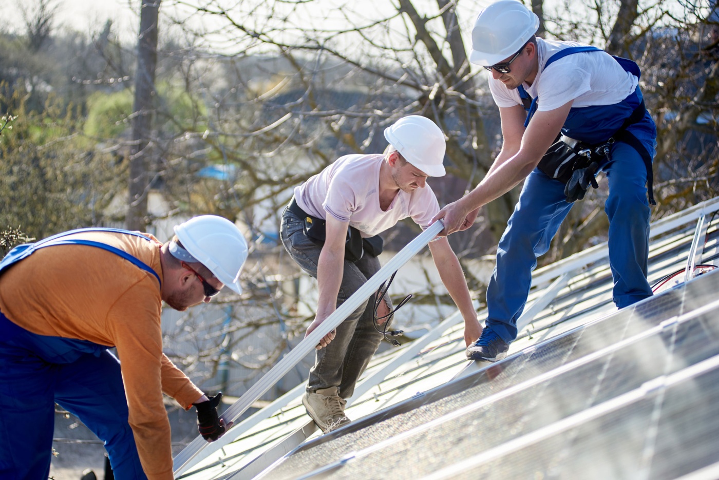 Three men installing solar panels