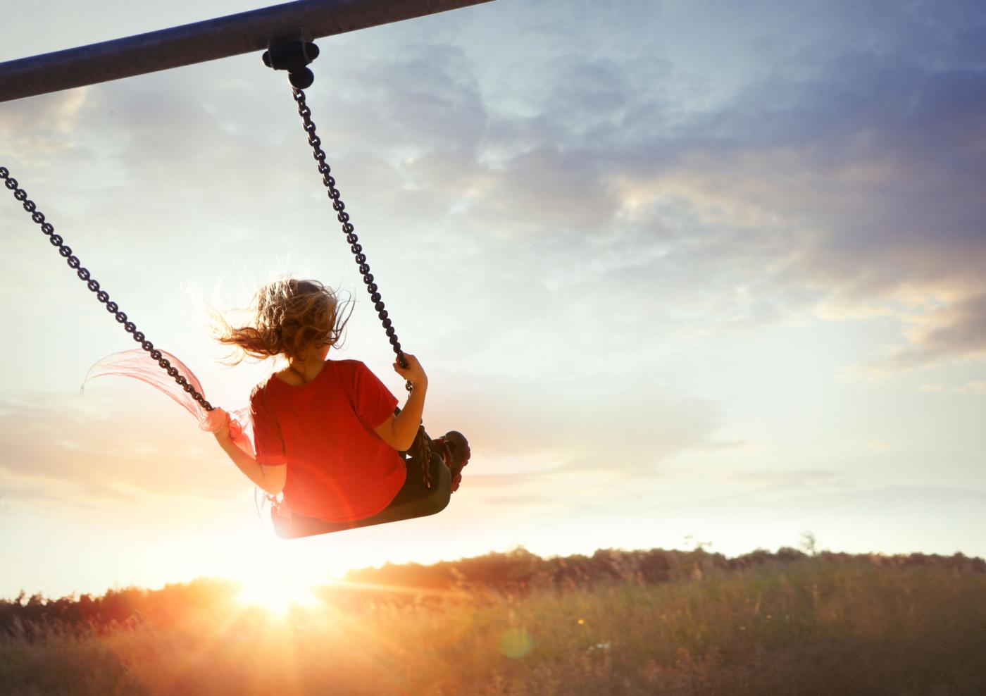 Girl on a swing at sunset