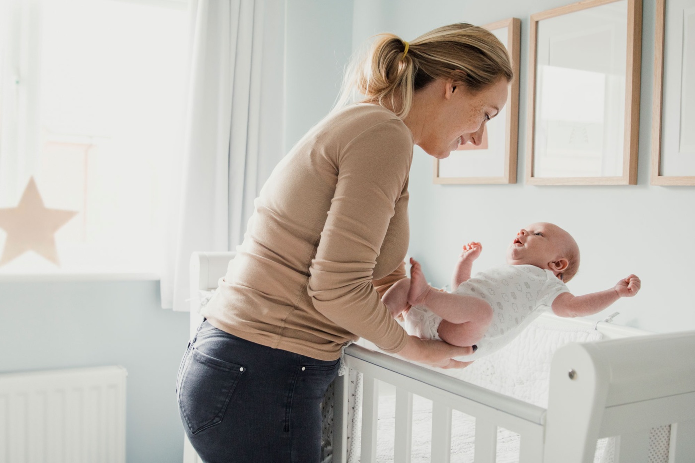 Mom picks up baby from crib