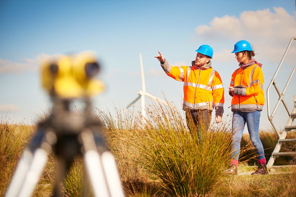 Two workers walk near wind turbine