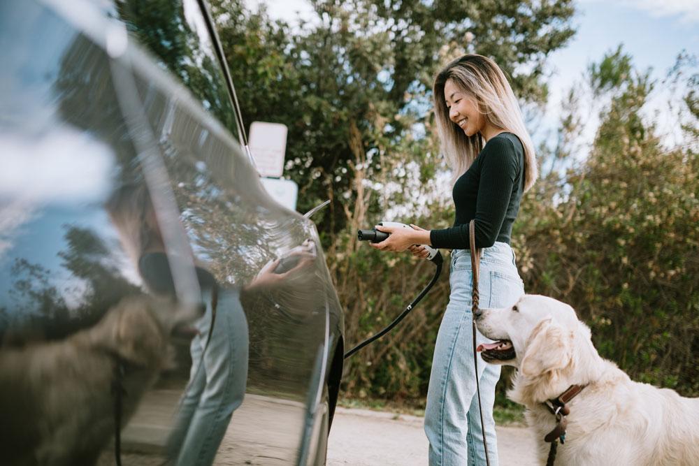 Woman with dog charges electric car