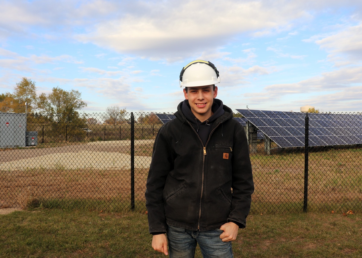 Micah Rivera near solar panels