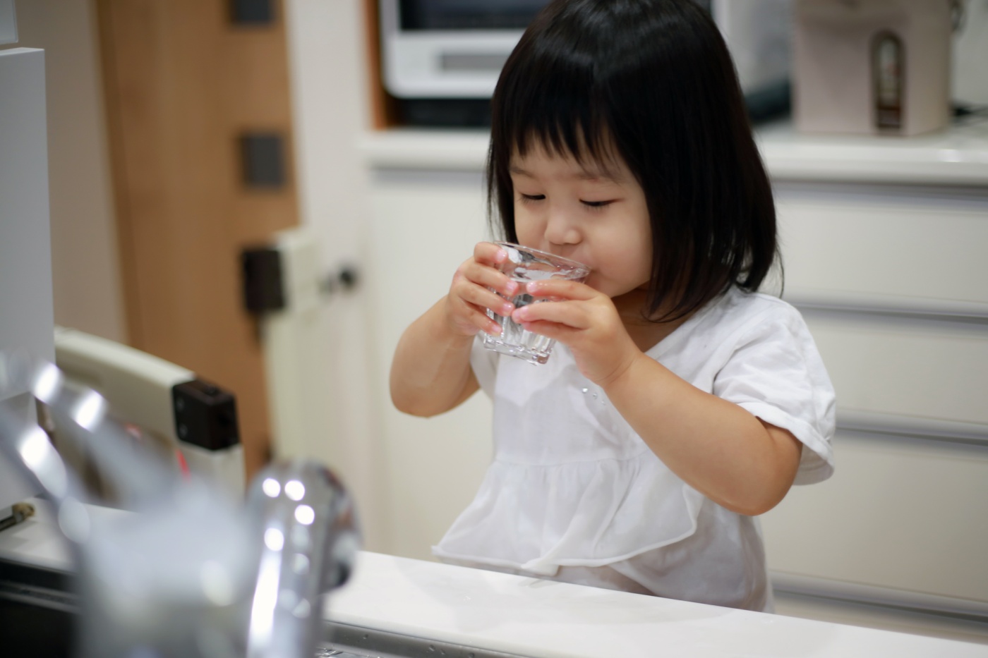 Child drinks a glass of water