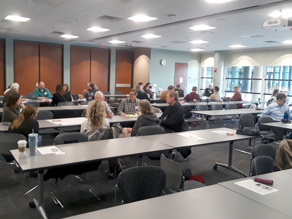 many people talking to each other in a conference room