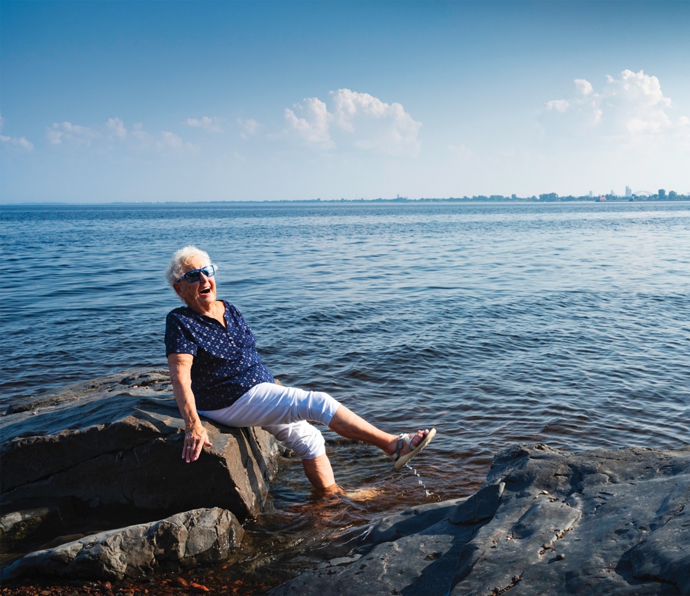 Joyful senior dipping feet in Lake Superior in Duluth