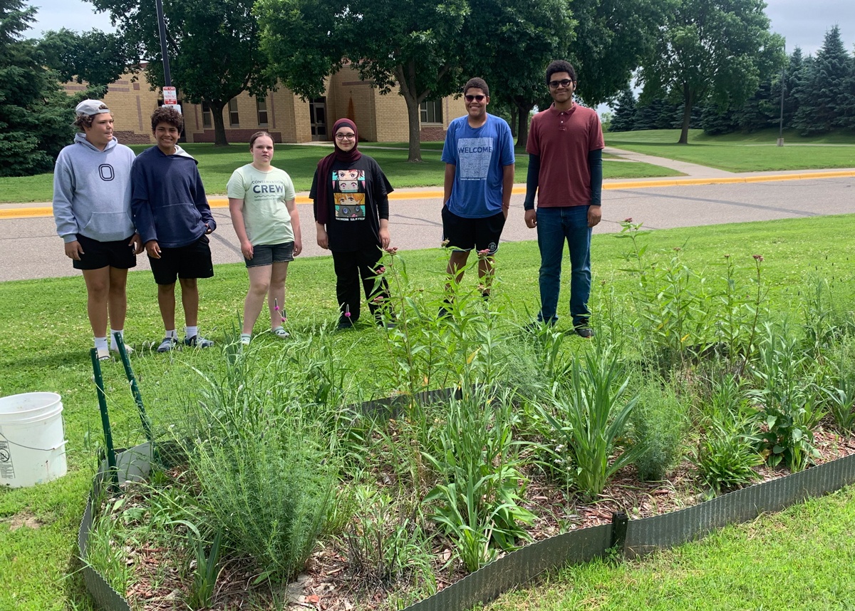 Students stand proudly by their garden