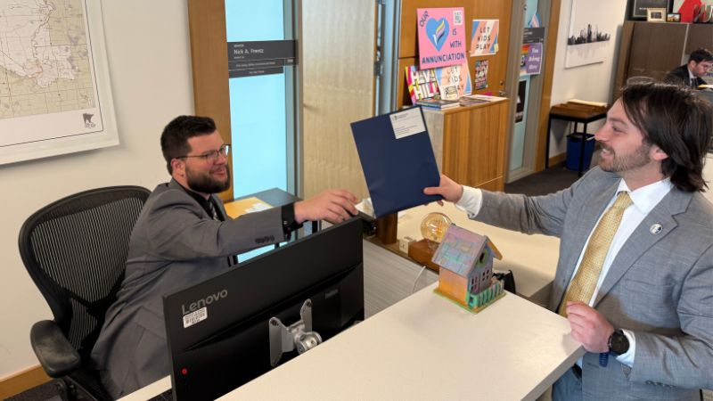 Conservation Minnesota's James Lehner delivers constituent postcards to Travis Urness, Legislative Assistant to Senate Assistant Majority Leader Nick Frentz
