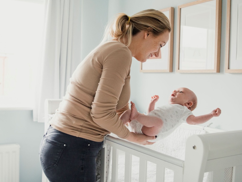 Mom picks up baby from crib