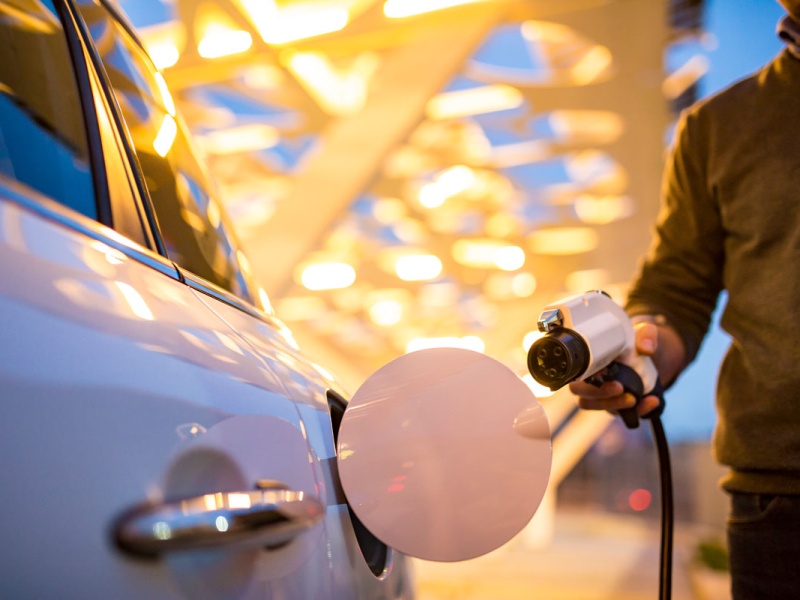 person at an electric vehicle charging station 