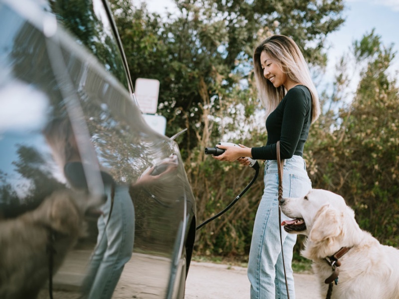 Woman with dog charges electric car