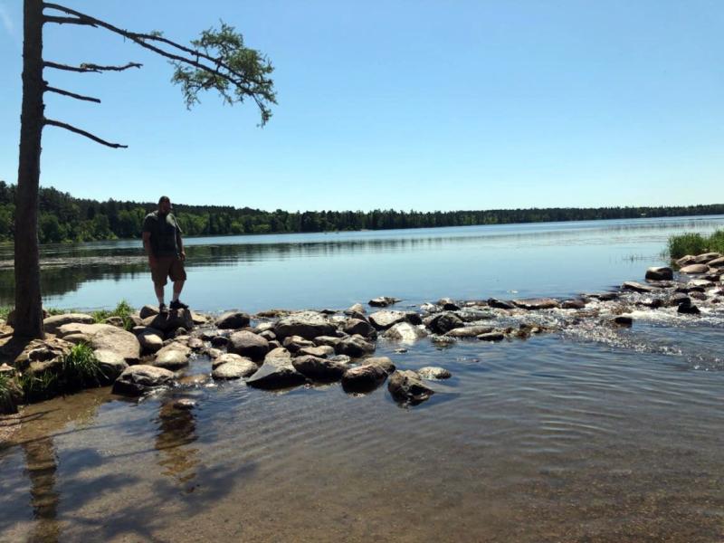 Person stands by rocks at Mississippi headwaters
