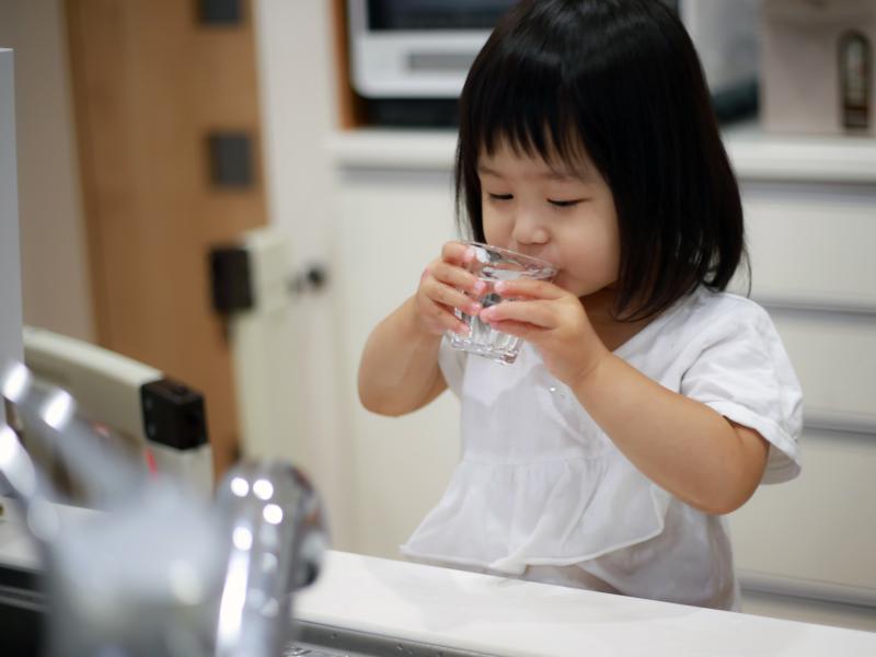 Child drinks a glass of water