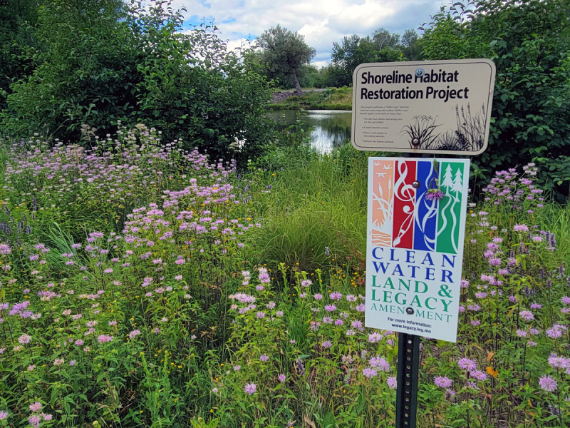 Clean Water Land and Legacy sign by prairie and pond