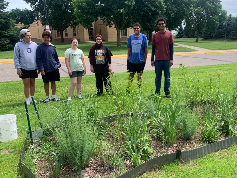 Students stand proudly by their garden