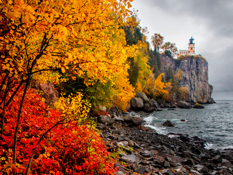 Split Rock Lighthouse in the distance overlooks Lake Superior in the fall