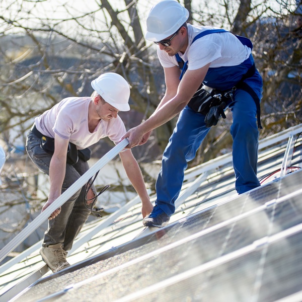 Three men installing solar panels